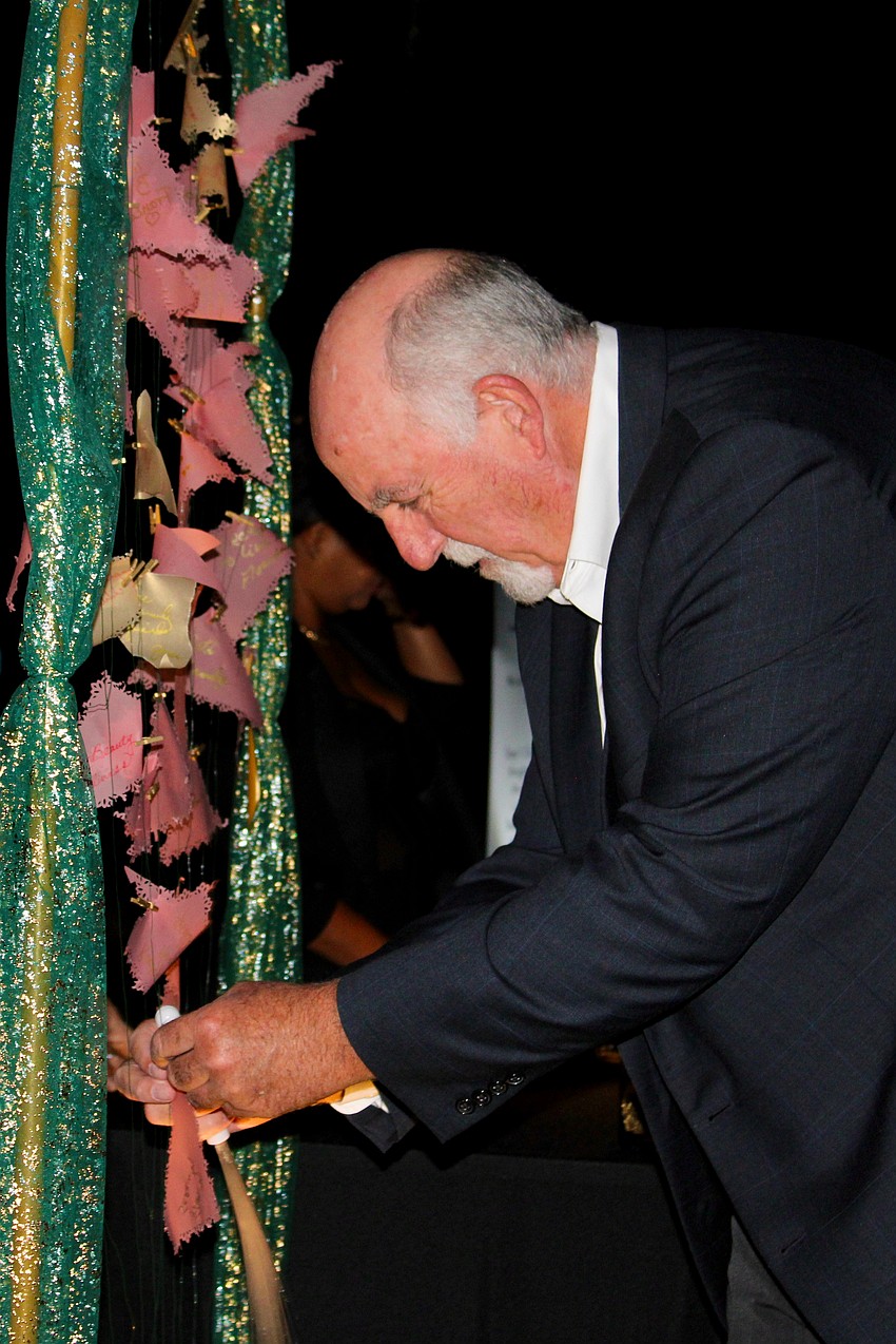 Neil Kilbane, attending Party in Paradise with Caroline Kilbane, places a leaf in an interactive 
