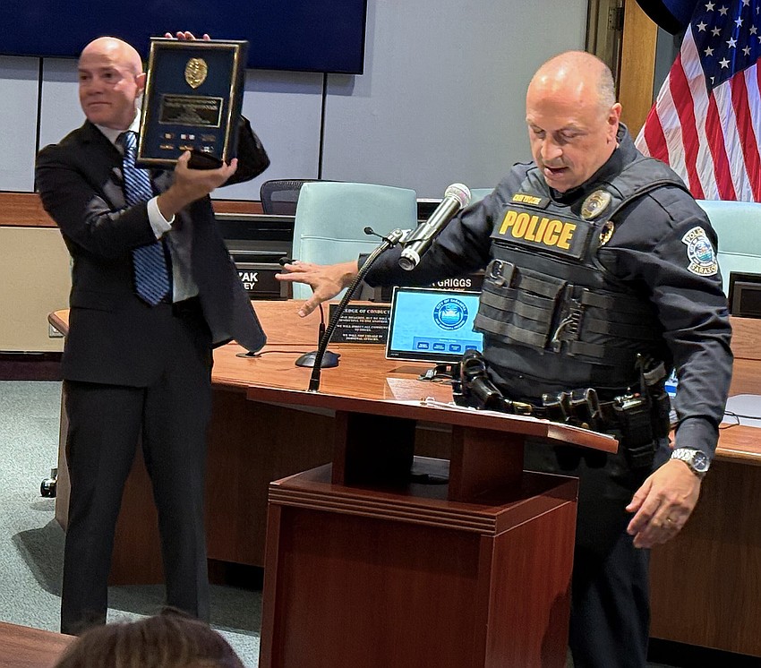 Retired SPD Capt. Demitri Konstantopoulos displays his shadow box as Police Chief Rex Troche speaks.