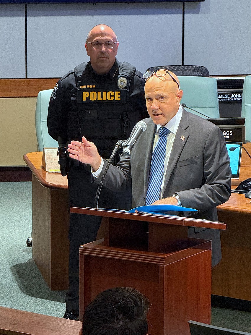 Sarasota Police Department Capt. Demetri Konstantopoulos speaks to the crowd of nearly 100 who gathered to celebrate his retirement as Chef Rex Troche looks on.