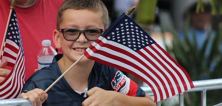 Lakewood Ranch's Vincent Van Slyck keeps his flag waving during the Tribute to Heroes Parade Nov. 9 at Main Street at Lakewood Ranch.