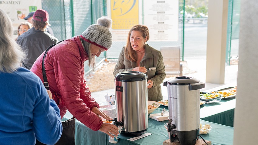 Alice Edwards helps herself to some hot cocoa at the welcome back event at the Longboat Key Tennis Center Tuesday, Nov. 11.