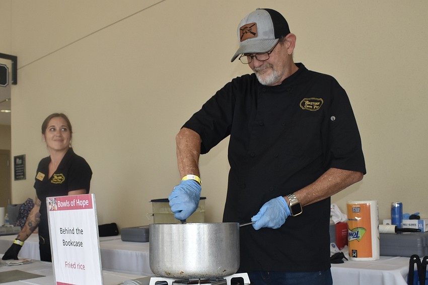 Christy Palenske looks on as Mark Koplau stirs soup.