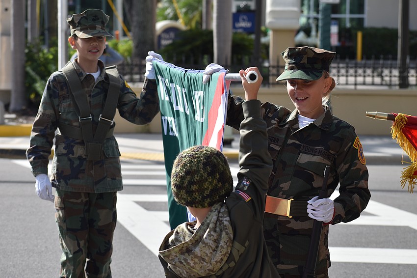 Kindergartener Henry Schaefer (front) helps out seventh graders Dominic Shattuck and Mailin Kirchherr, of Venice Middle School, with a banner.