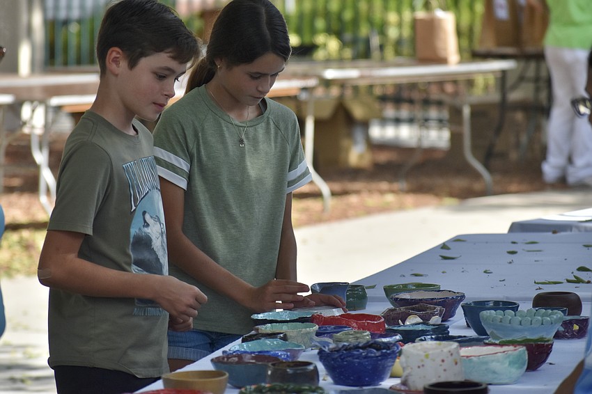 Grady Bernas, 10, and Avery Bernas, 12, look over the bowls.