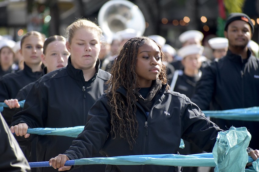 Sarasota High School's marching band heads along the parade route, with junior Kyla Woodard in front.