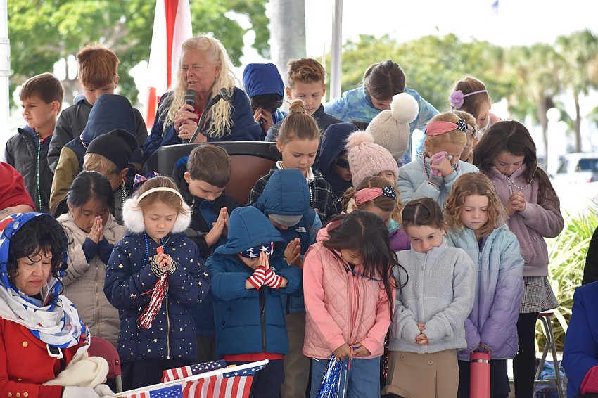 Jan Solomon leads the invocation with students from First Sarasota Montessori Academy.