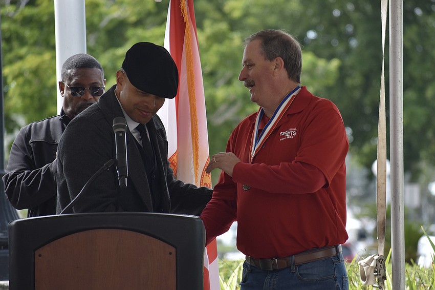 Carlos Moreira presents Rob Kehs, male veteran of the year, with a medal.