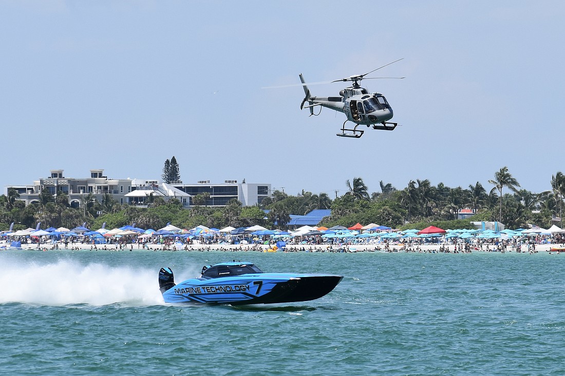 The T/S Motorsports / Marine Technology boat piloted by Taylor Scism of Missouri and Johnny Tomlinson of North Miami, Florida passes crowds of spectators on the beach.