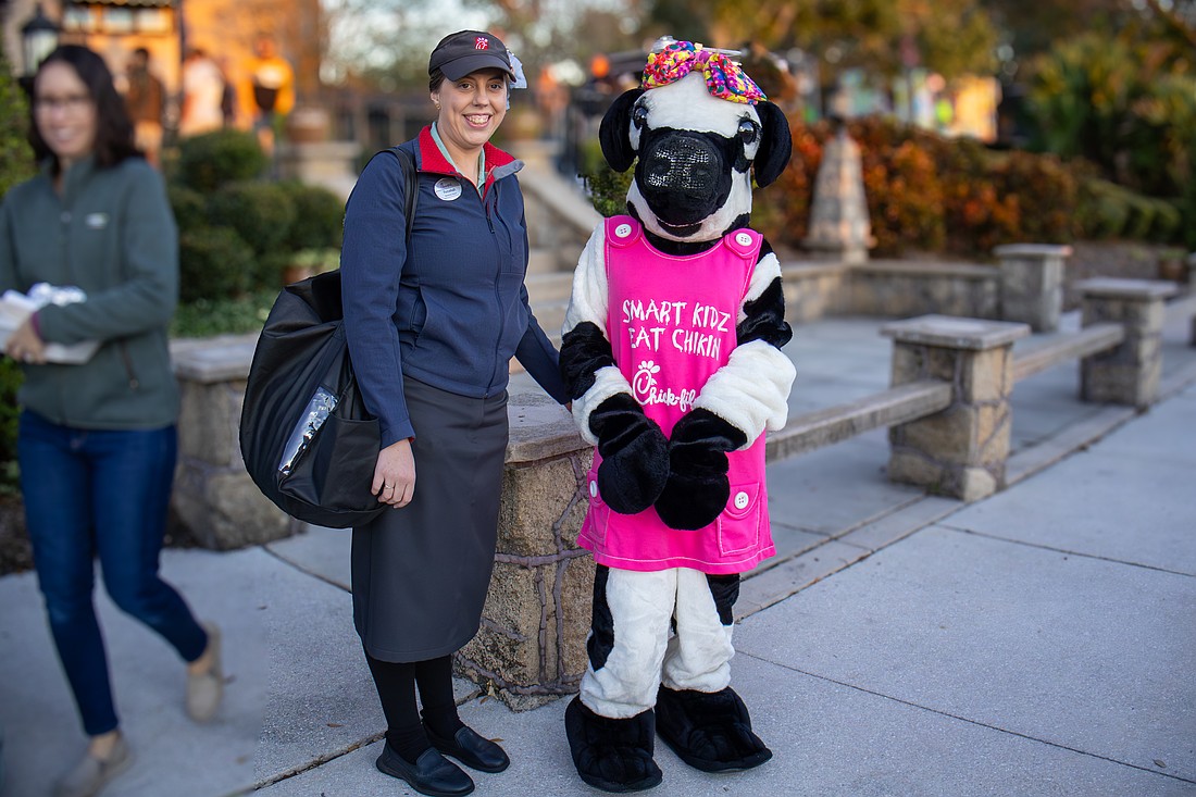 Chick-Fil-A marketing director Rebekah Petrick stands next to the mascot. Photo by Sydney Tevin