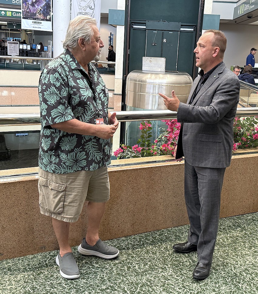 Sarasota-Bradenton International Airport President and CEP Paul Hoback visits with SRQ information desk volunteer member Rafik Accad