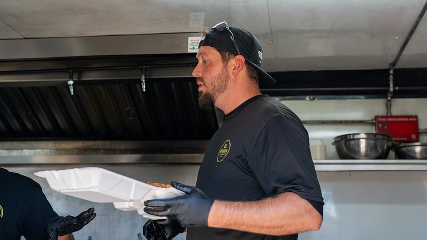 Bradentrucky Grub Truck owner Brandon Kelle packages a meal for a town employee at Rotary Club of Longboat Key’s Nov. 12 Food for Gratitude event where all town employees received free lunch to recognize their hard work after dual hurricanes in 2024.
