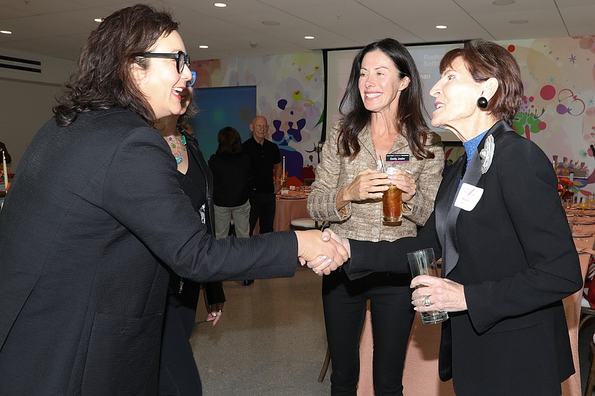 Gloria Sutton greets guests Emily Joslin and Alison Gardner.