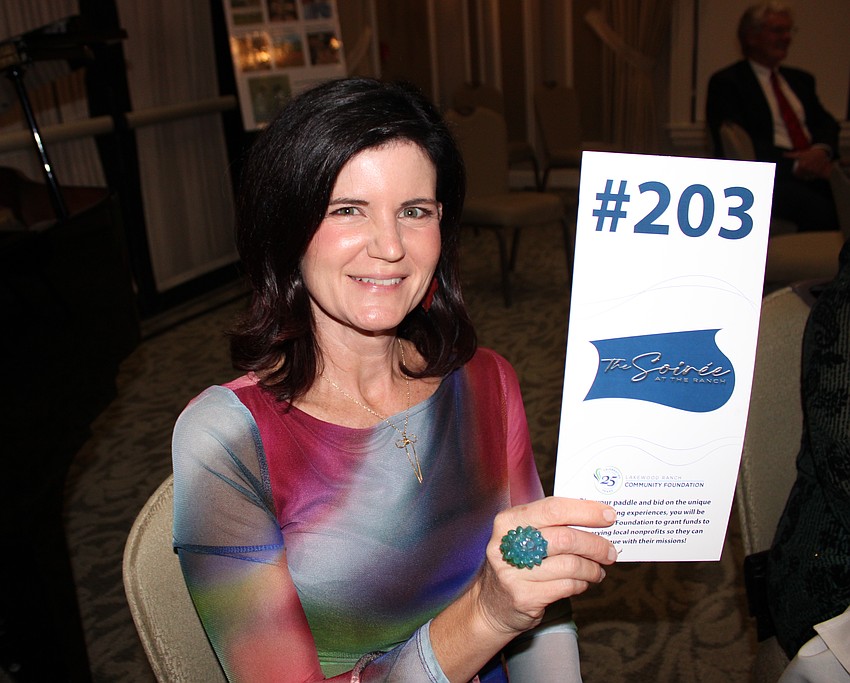 Hannah Toale holds up bid No. 203 for a hefty donation to the Lakewood Ranch Community Foundation during The Soirée at the Ranch Nov. 13.