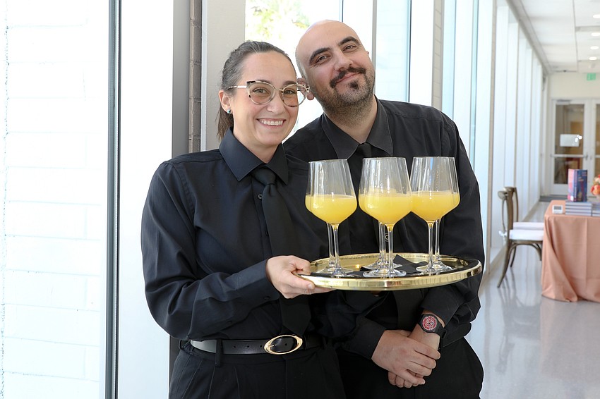 Kaitlynd Zimmer and Iliyan Ivanov greet guests with mimosas.