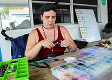 Sarasota Ski-A-Rees sound technician Madison Ditmars demonstrates how she makes the crab figurines she offers by donation to support the group in its ongoing recovery from last year's hurricanes.
