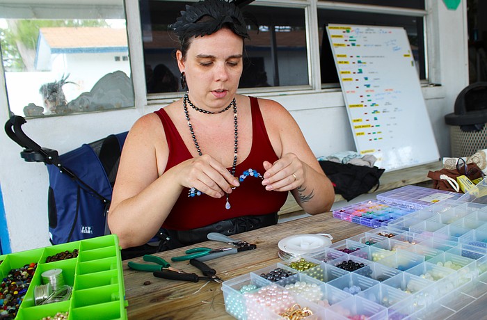 Sarasota Ski-A-Rees sound technician Madison Ditmars demonstrates how she makes the crab figurines she offers by donation to support the group in its ongoing recovery from last year's hurricanes.