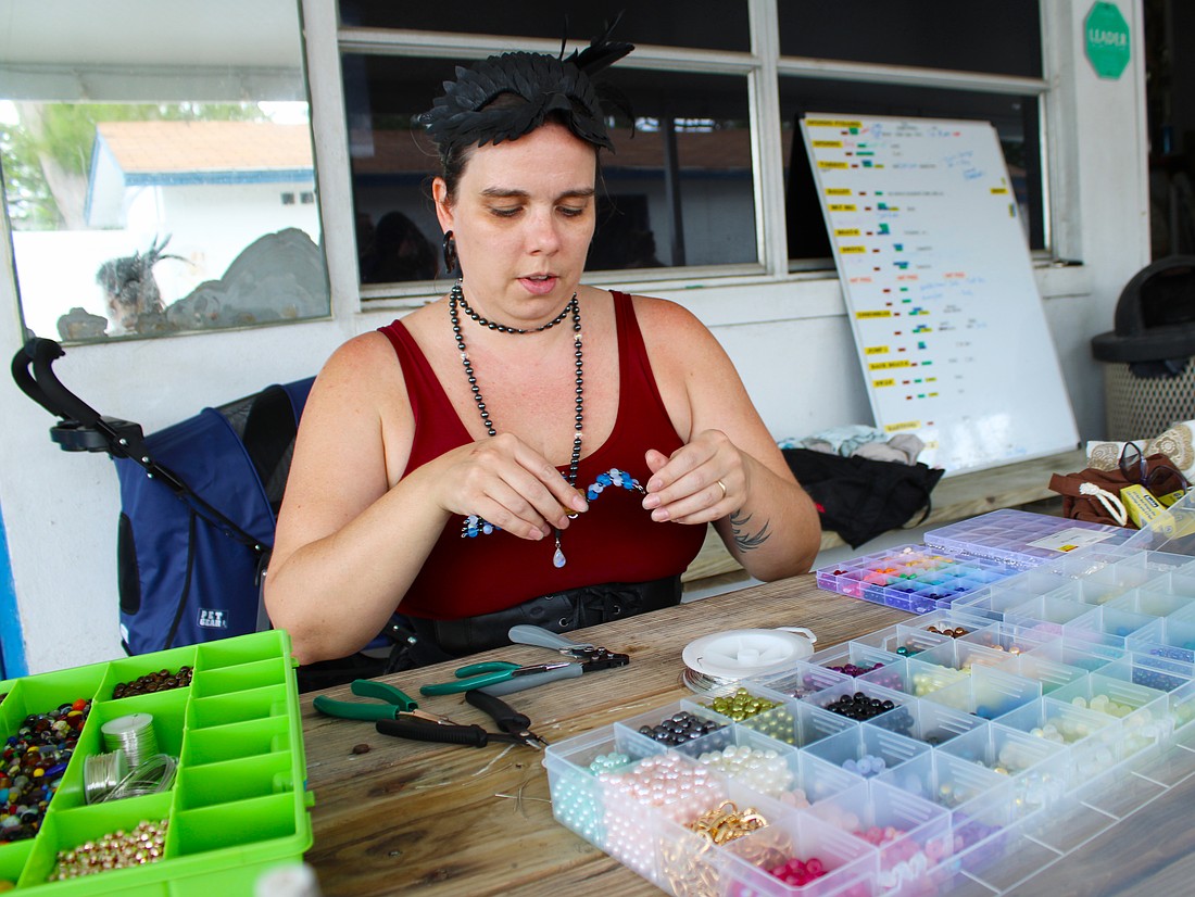 Sarasota Ski-A-Rees sound technician Madison Ditmars demonstrates how she makes the crab figurines she offers by donation to support the group in its ongoing recovery from last year's hurricanes.