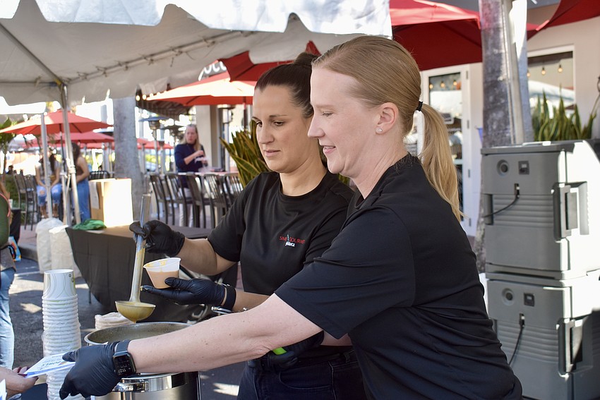 Jessica Dellamico and Becky Souflis are serving lobster and shrimp bisque from Simply Gourmet by Metz.