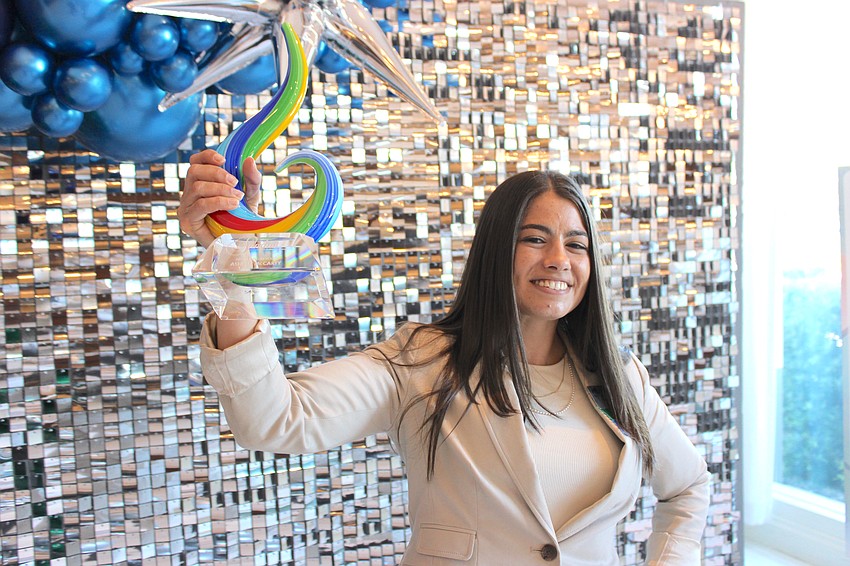 Ashlyn McCarty of Buffalo Lodging shows off her Above and Beyond award she earned at the 2025 Sandies luncheon at the Grove in Lakewood Ranch.