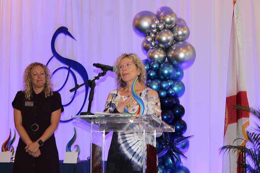 Lakewood Ranch Business Alliance CEO and President Brittany Lamont looks on as Lori Abramson of LegalShield accepts the Best Rancher award.