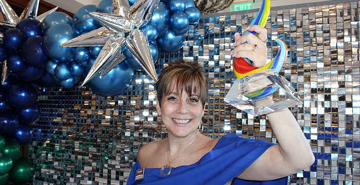 Shawna Hicks-Cranston of PostNet raises her Sandies award for the Community Champion category. The annual Sandies was held by the Lakewood Ranch Business Alliance Nov. 14 at the Grove in Lakewood Ranch.