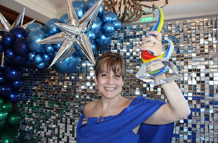 Shawna Hicks-Cranston of PostNet raises her Sandies award for the Community Champion category. The annual Sandies was held by the Lakewood Ranch Business Alliance Nov. 14 at the Grove in Lakewood Ranch.