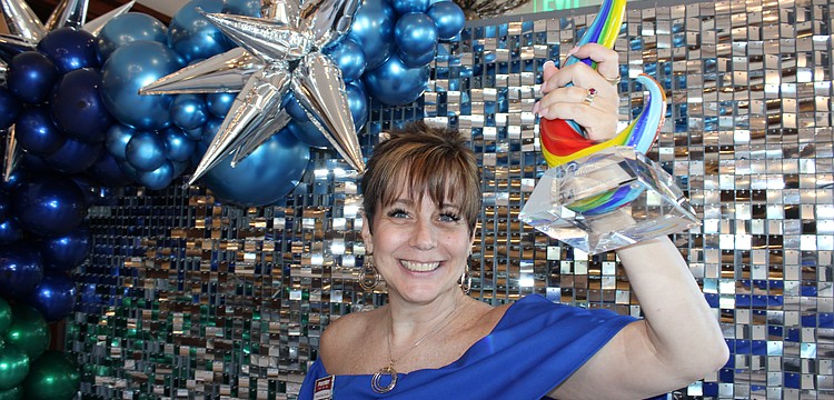 Shawna Hicks-Cranston of PostNet raises her Sandies award for the Community Champion category. The annual Sandies was held by the Lakewood Ranch Business Alliance Nov. 14 at the Grove in Lakewood Ranch.