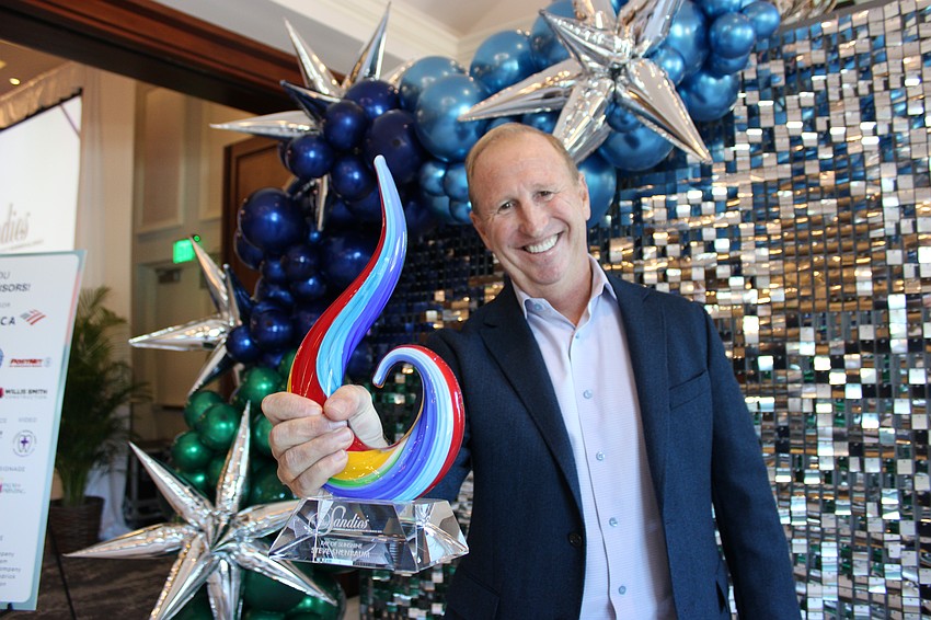 Steve Shenbaum of Game On Nation shows off the trophy for his selection as the 2025 Ray of Sunshine for the Lakewood Ranch Business Alliance.