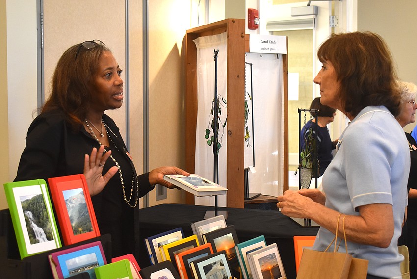 Benise Jones and Kim DePoy bond about both living in Esplanade at Azario. DePoy purchased a decorated sticky note pad and a custom journal from Jones.