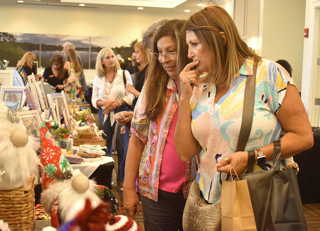 Sarasota's Julia Wilhelm and Renee Myers check out the pieces of art for sale at LKM Fanciful Creations by Linda McMillan.