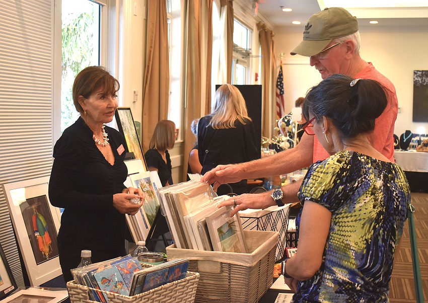 Gail Cristello of Artwork by Gail visits with Venice's Laura and Tim Eaton as they browse through her items for sale.