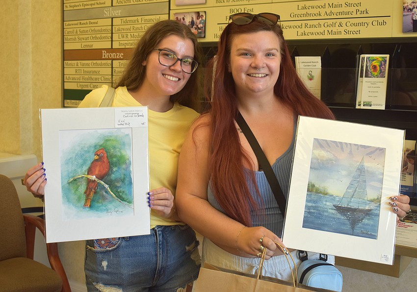 Lakewood Ranch's Abby Mathews and Englewood's Mackenzie Mills pose with artwork they purchased from Stacey Lipton Interiors.