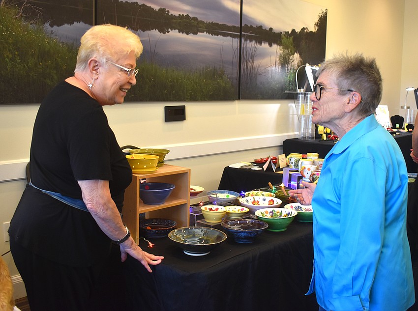 Barb Kaplan, who sells functional ceramics, reunites with Sue Kerr who is usually a vendor in the show herself with raku fired pottery. Kerr said she is good friends with the vendors and was happy to see them as she hasn't seen them in a while.