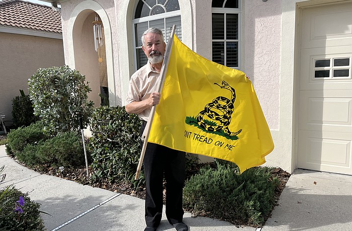 John Morrison takes his Gadsden flag down after receiving two notices from his homeowners association saying the flag violates community deed restrictions.