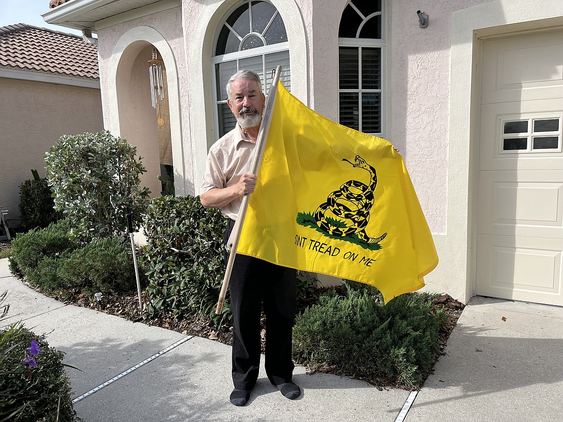 John Morrison takes his Gadsden flag down after receiving two notices from his homeowners association saying the flag violates community deed restrictions.