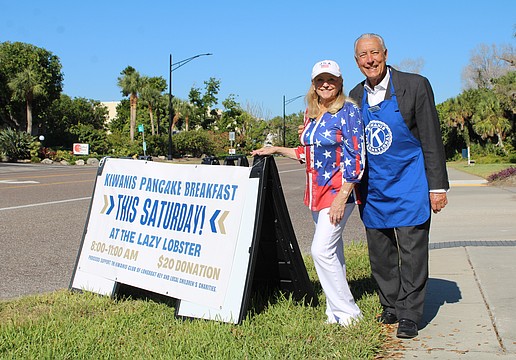 Phyllis Black and Andrew Vac flag down hungry diners to join the Kiwanis Club of Longboat Key's pancake breakfast fundraiser on Nov. 15 at the Lazy Lobster.