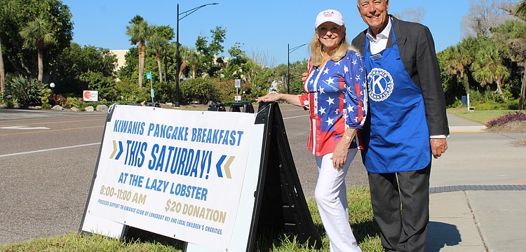 Phyllis Black and Andrew Vac flag down hungry diners to join the Kiwanis Club of Longboat Key's pancake breakfast fundraiser on Nov. 15 at the Lazy Lobster.