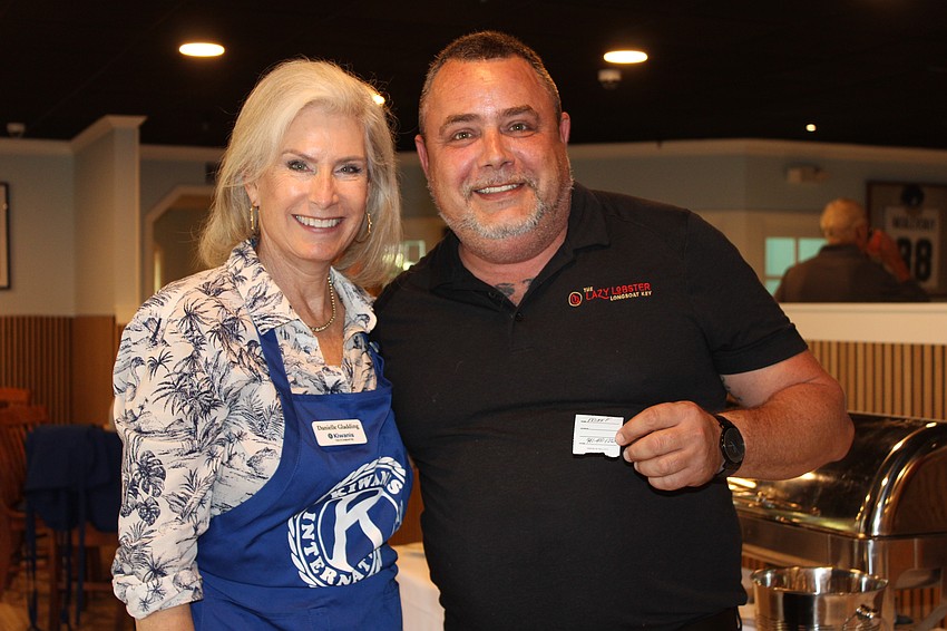Kiwanis Club of Longboat Key president Danielle Gladding congratulates Mike Frashier on his raffle win at the conclusion of the Nov. 15 pancake breakfast fundraiser.