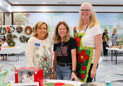 Elaine Cichon, Lorri Harrison and Claudia Stieber bring their festive spirit to the St. Mary, Star of the Sea, Catholic Church annual Christmas bazaar, held last weekend at the church.