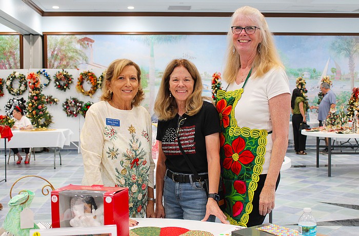 Elaine Cichon, Lorri Harrison and Claudia Stieber bring their festive spirit to the St. Mary, Star of the Sea, Catholic Church annual Christmas bazaar, held last weekend at the church.