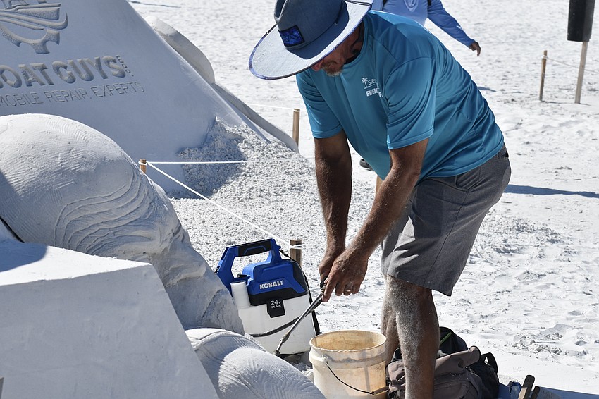 Andy Daily performs repair work on a sculpture.
