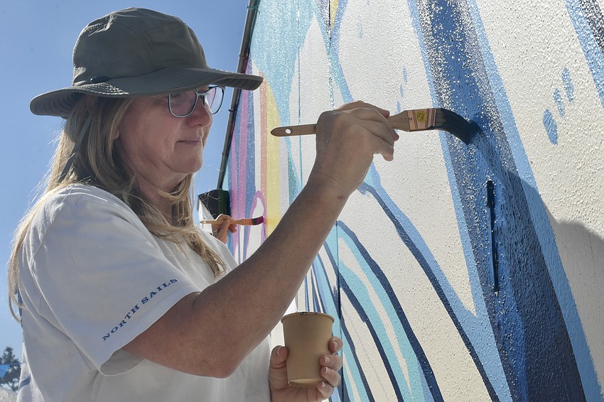 Michelle Lee paints the mural.