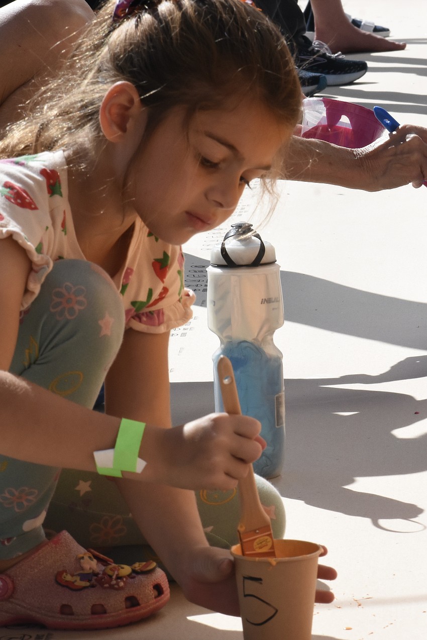 Ava Luber, 6, paints the mural.