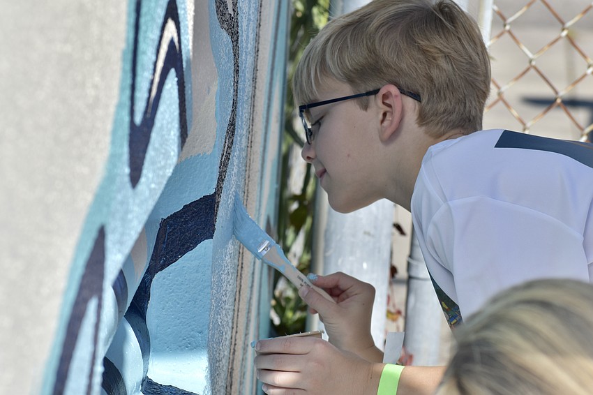 Dave Drake, 9, paints the mural.
