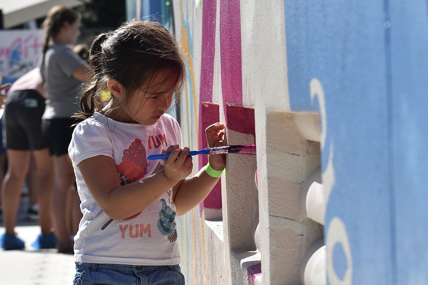 Celia Chau, 5, paints the mural.