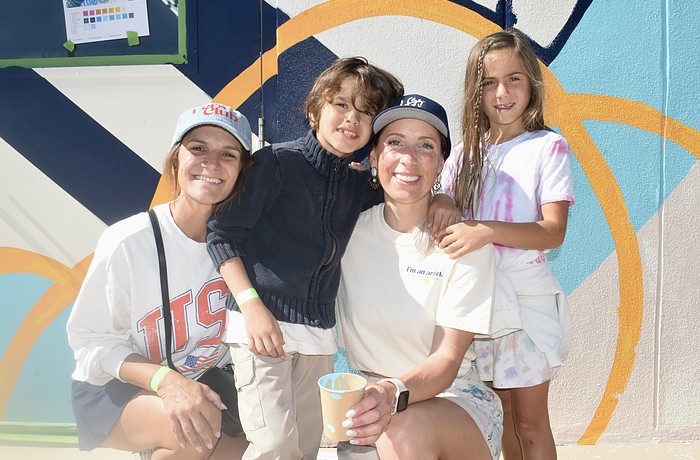 Sheena Works, Sebastian Works, 7, Alissa Silvers, and Isabella Coulton, 7, pose together in front of the mural.