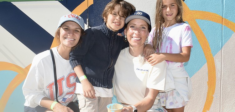 Sheena Works, Sebastian Works, 7, Alissa Silvers, and Isabella Coulton, 7, pose together in front of the mural.