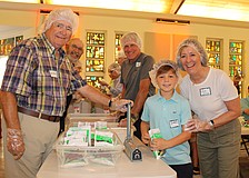 Bert Wood, Karl Kaminski, Hudson Nesmith and Jane Conrad were among the 120 volunteers helping pack meals for Kids Against Hunger on Nov. 8 at St. Armands Key Lutheran Church. Part of the meals went to help local families, and part went to support hurricane survivors in Jamaica.