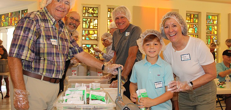 Bert Wood, Karl Kaminski, Hudson Nesmith and Jane Conrad were among the 120 volunteers helping pack meals for Kids Against Hunger on Nov. 8 at St. Armands Key Lutheran Church. Part of the meals went to help local families, and part went to support hurricane survivors in Jamaica.