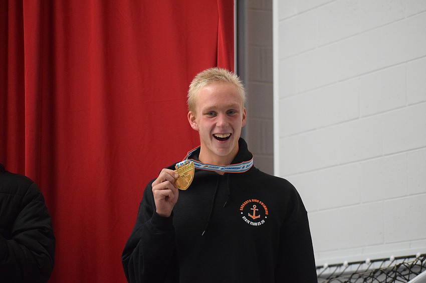 Senior Bogdan Zverev smiles and holds his gold medal. He won a team-high four medals, proving instrumental in the Sailors' ultimate victory.